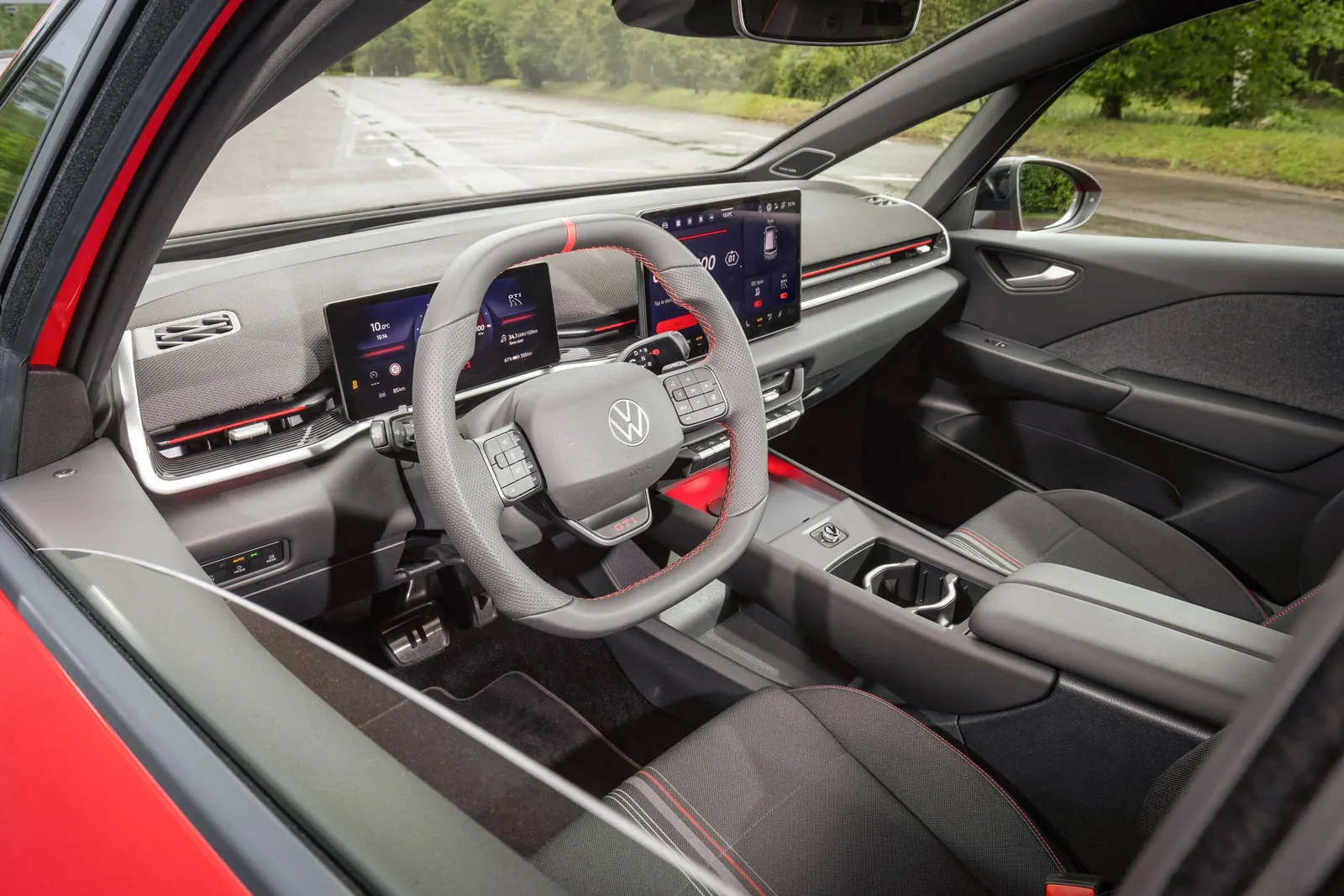Cockpit des Volkswagen ID.3 GTI mit roter Lenkradmarkierung, zwei Displays und Tasten unter dem Zentralbildschirm.